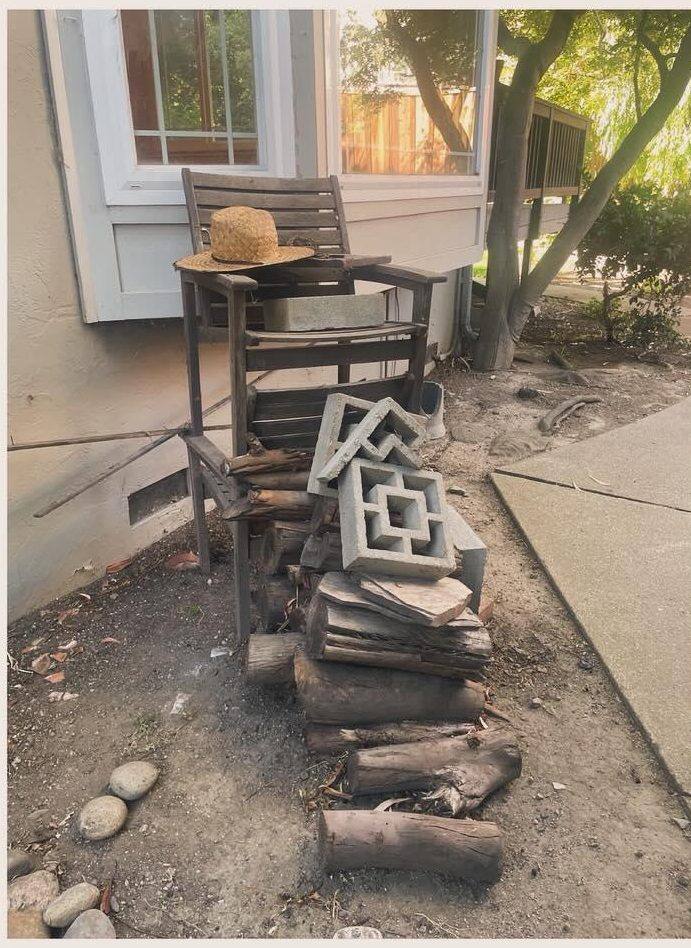 Yard with stacked bricks and old chairs before removal