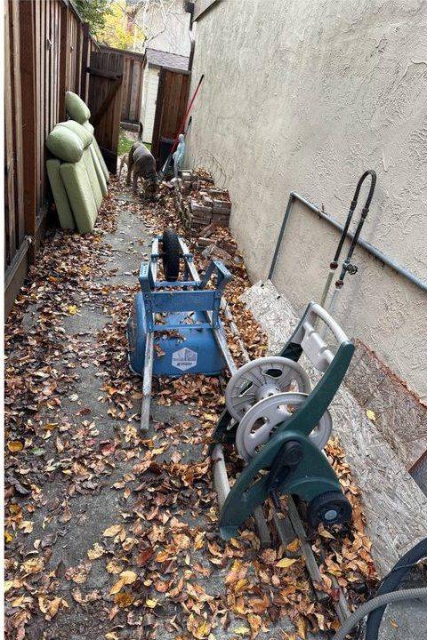 Side yard cluttered with equipment and leaves before clean-up